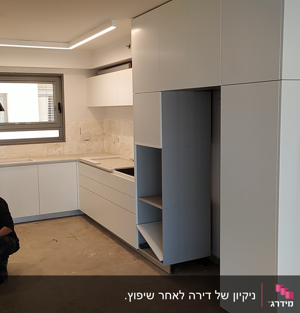 אדם מנקה מטבח עם חומרי ניקוי על הרצפה